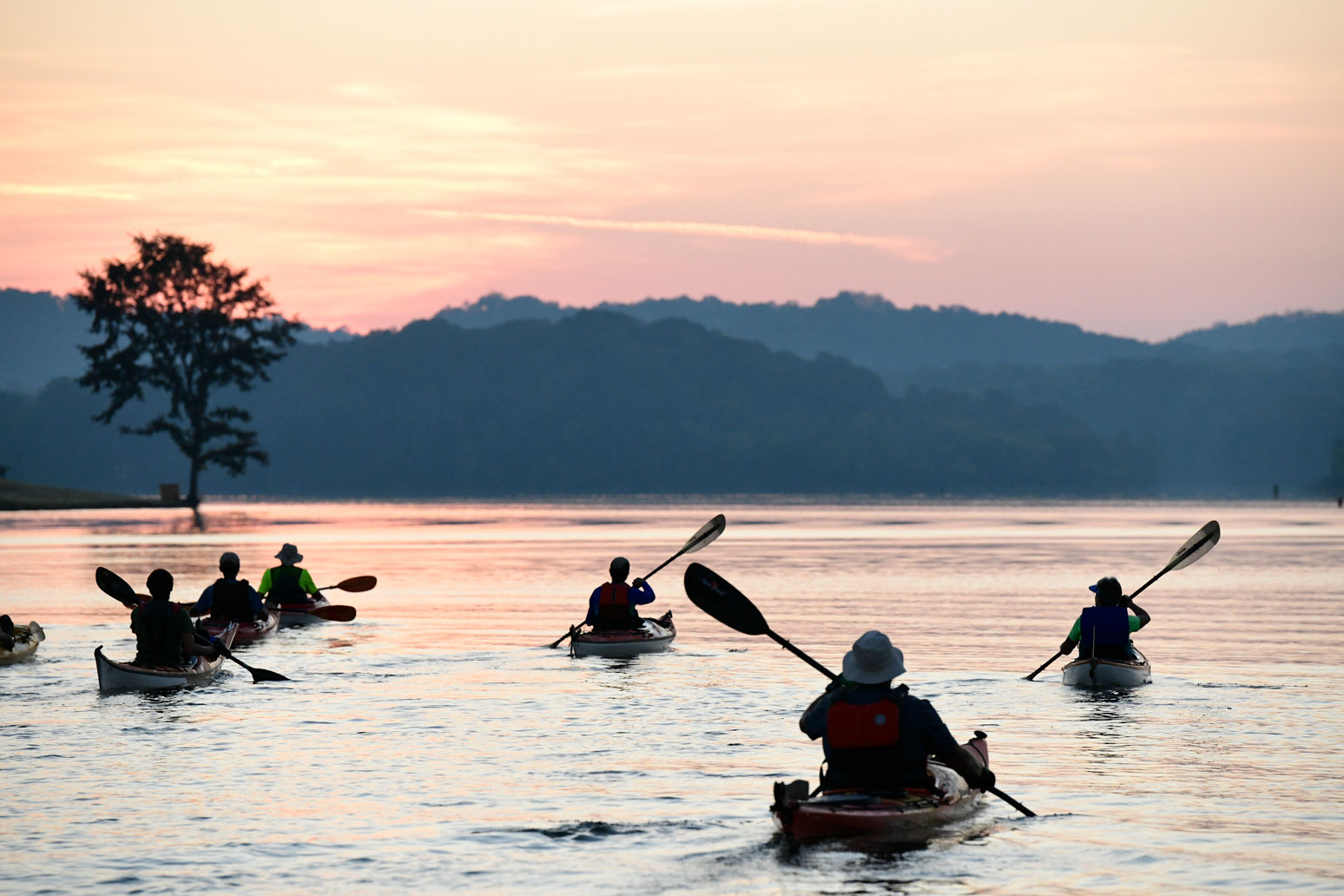 Villagers kayaking at sunrise.